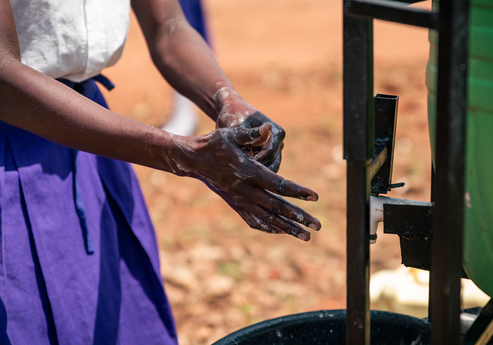 Eine Schülerin in Uganda an einer Handwaschstation. Foto: Leo Müller